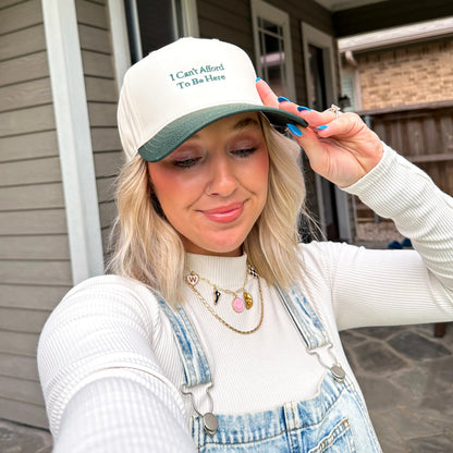 Woman wearing a cap and overalls standing on a porch