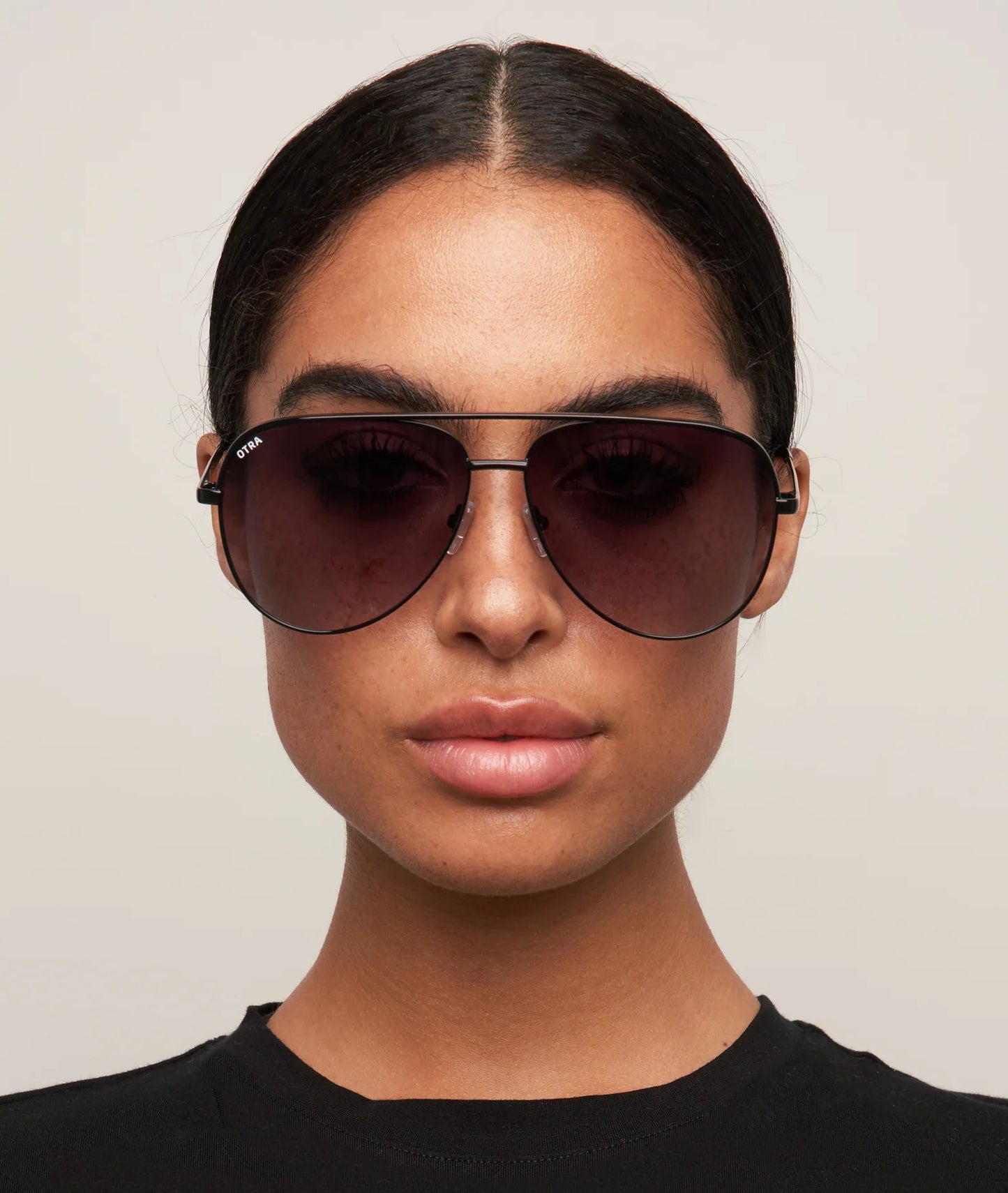 Person wearing dark sunglasses against a neutral background
