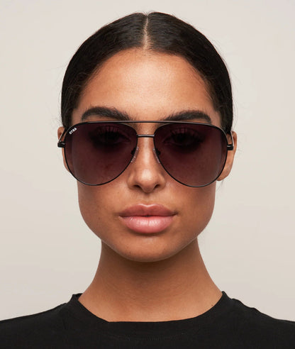 Person wearing dark sunglasses against a neutral background