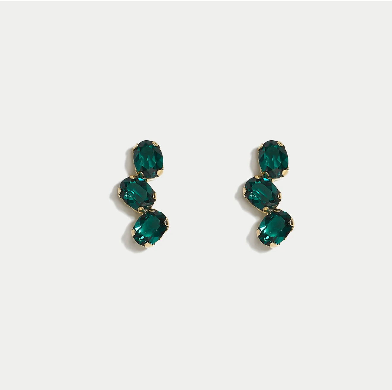 Pair of green swarovski crystals earrings on a white background