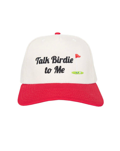 A baseball cap with an off-white crown and a red curved brim. The front of the cap features the embroidered text 'Talk Birdie to Me' in black script, accompanied by a small red flag and green putting green graphic.