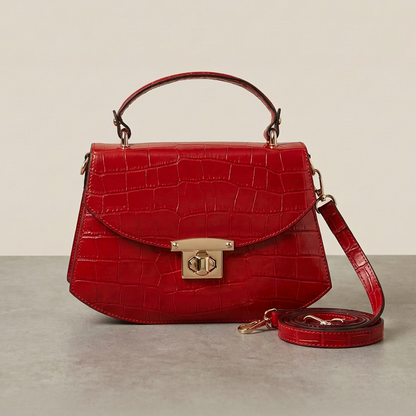 Red handbag with gold accents on a neutral background