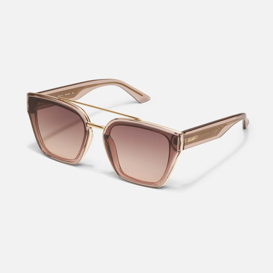 Sunglasses with gold frame and brown gradient lenses on a light gray background