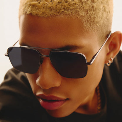 Person wearing black sunglasses with a neutral background