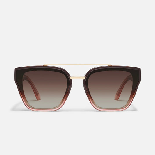 Sunglasses with brown gradient lenses and gold frame on a light gray background