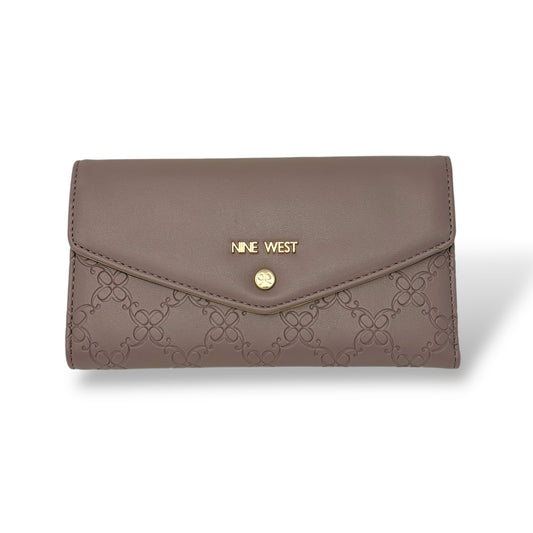 Nine West women’s trifold wallet. Rose quartz color with gold toned logo and snap button. Picture front facing view of the closed wallet with the logo and design showing 