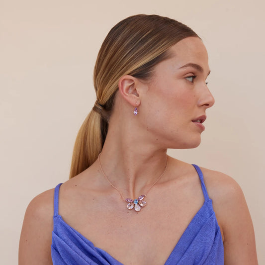 Woman wearing a necklace and earrings against a beige background
Material: 925 sterling silver, rhodium-plated, 6 Swarovski crystals
Color: silver, light pink, light blue, purple, and opal
Measurement: 14" length, 1" extension, 1 mm wide chain, pendant: 3.5 cm x 2.5 cm