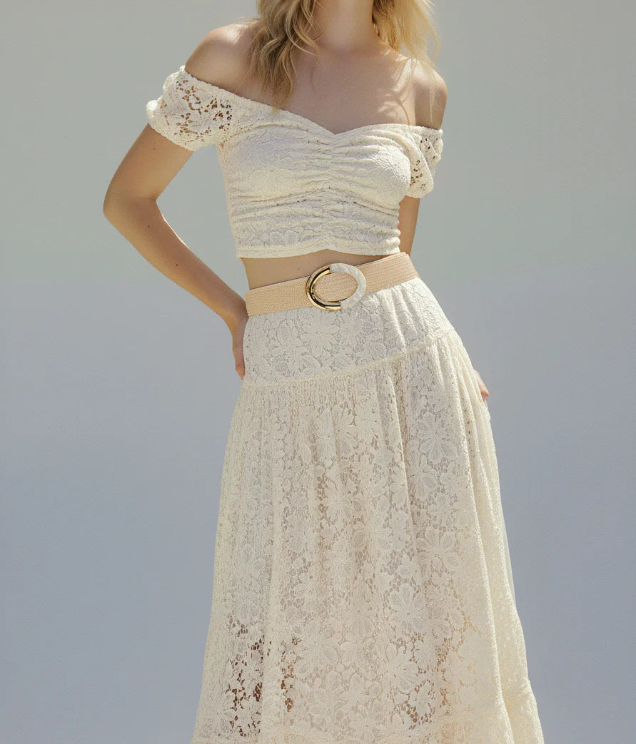 White lace dress with a belt on a plain background