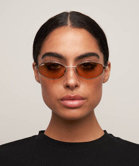 Person wearing brown sunglasses with a neutral background