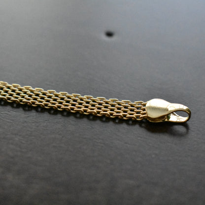 Gold chain with a clasp on a dark surface