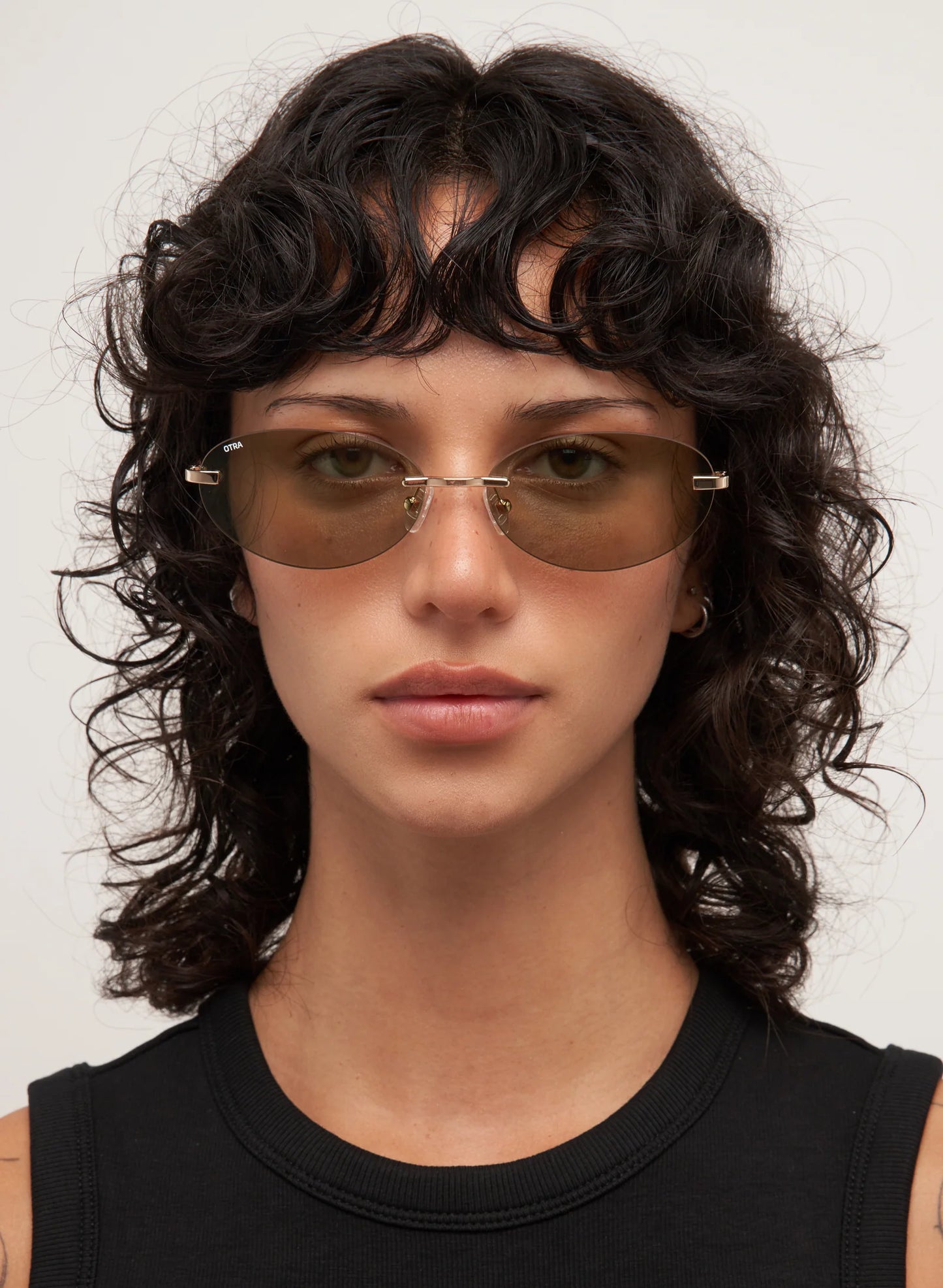 Woman wearing sunglasses with a neutral background