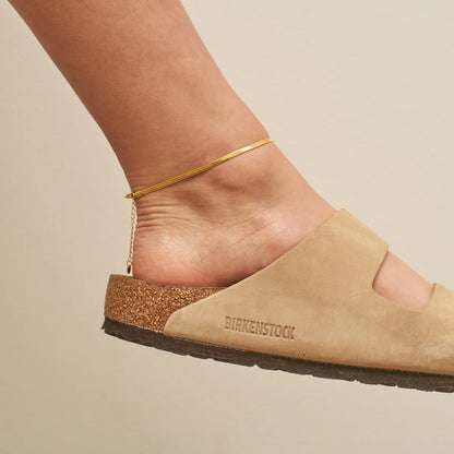 Beige sandal with 'Birkenstock' branding on a beige background