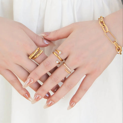 Gold rings and bracelet on a hand against a white background