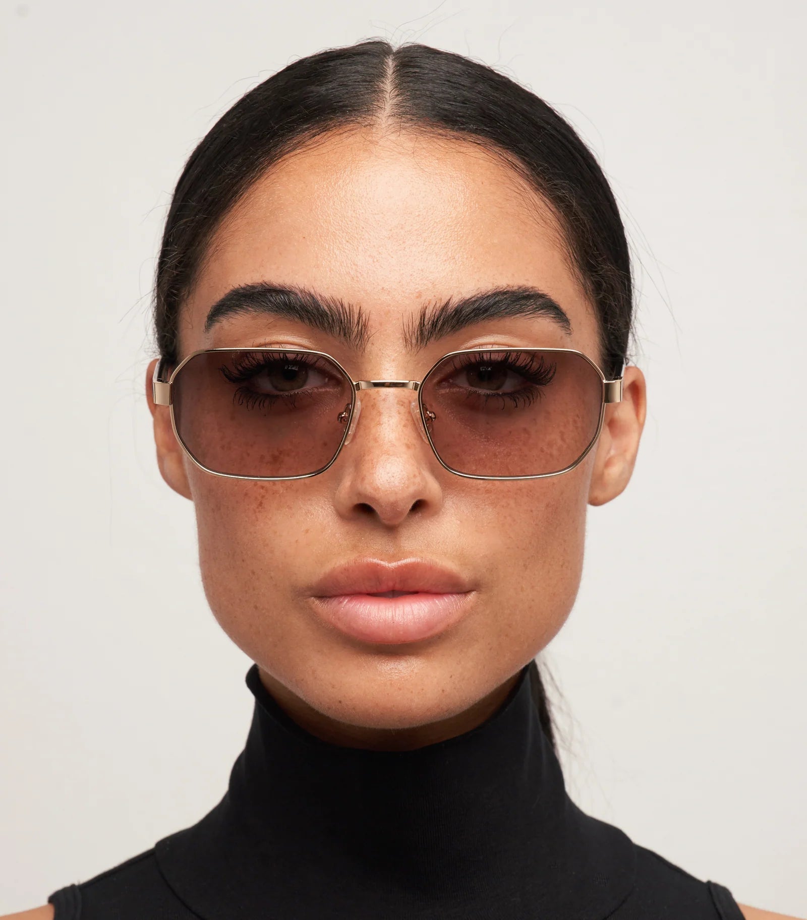 Woman wearing sunglasses with a plain background