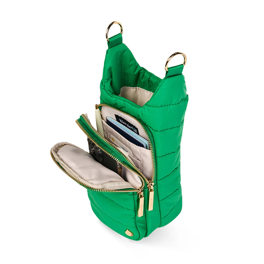 Green quilted handbag with gold zippers on a white background