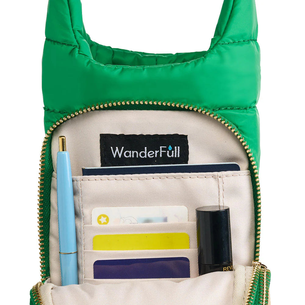 Green crossbody bag with 'WanderFull' label, showing interior compartments with items.