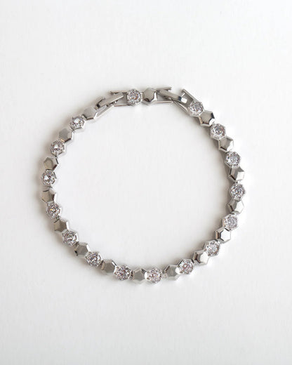 Silver bracelet with diamond accents on a white background