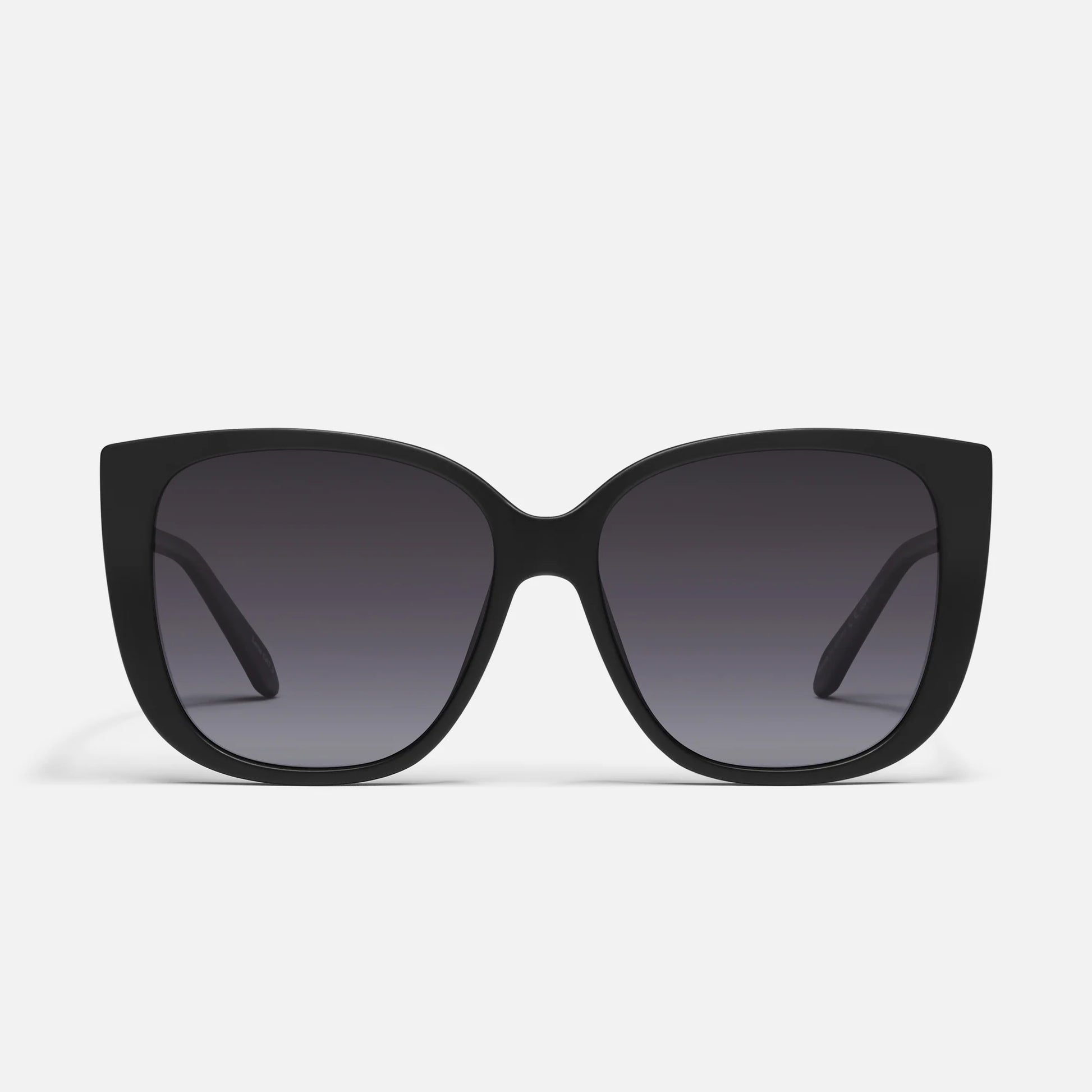 Black sunglasses with dark lenses on a light gray background