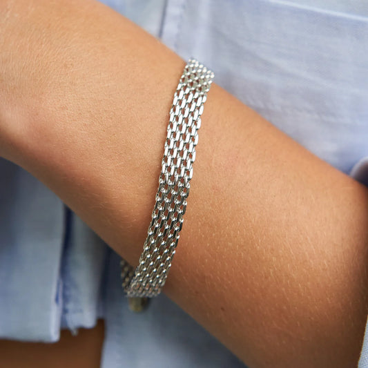 Silver chain bracelet on a wrist with a blurred background