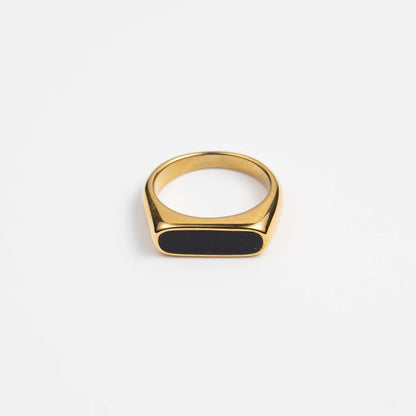 Gold ring with a black stone on a white background