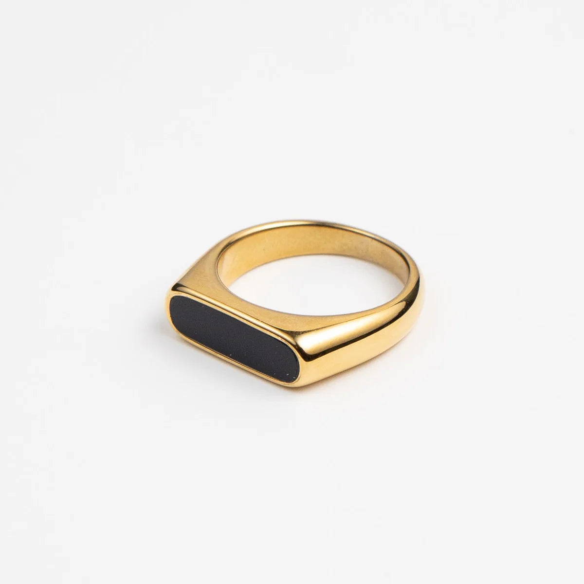 Gold ring with a black oval inset on a white background