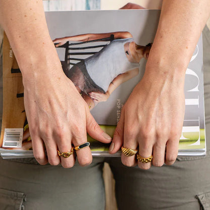 Person holding a magazine with visible jewelry