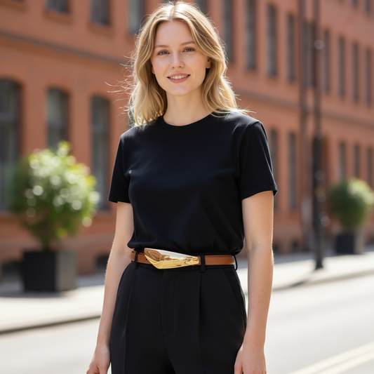 Woman wearing a black outfit with a gold belt in an urban setting