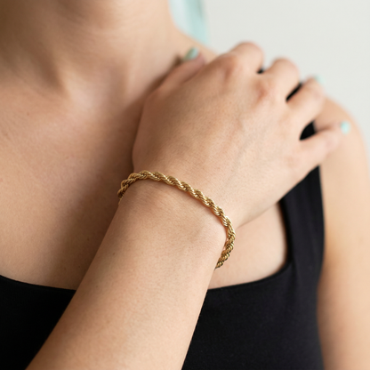Gold bracelet on a person's wrist with a blurred background
