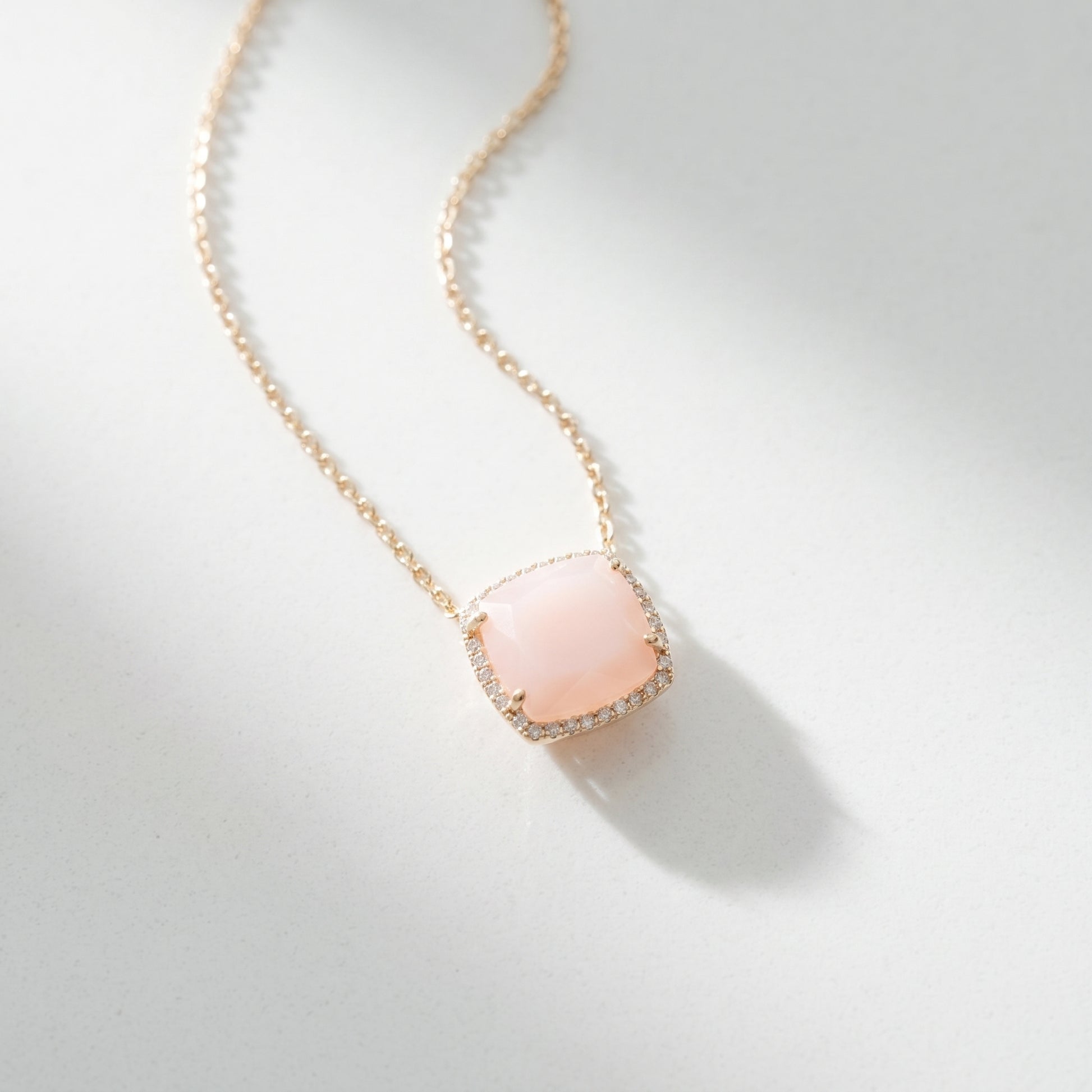 Necklace with a pink pendant on a light gray background