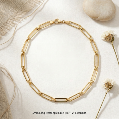 Gold chain necklace on a light background with natural elements