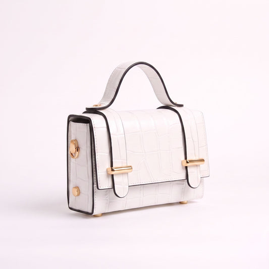 A structured white crocodile-embossed handbag with black trim, gold-tone hardware, and a top handle, photographed on a clean white background.