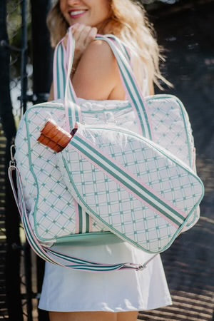 Woman holding a patterned bag with a visible brand logo.