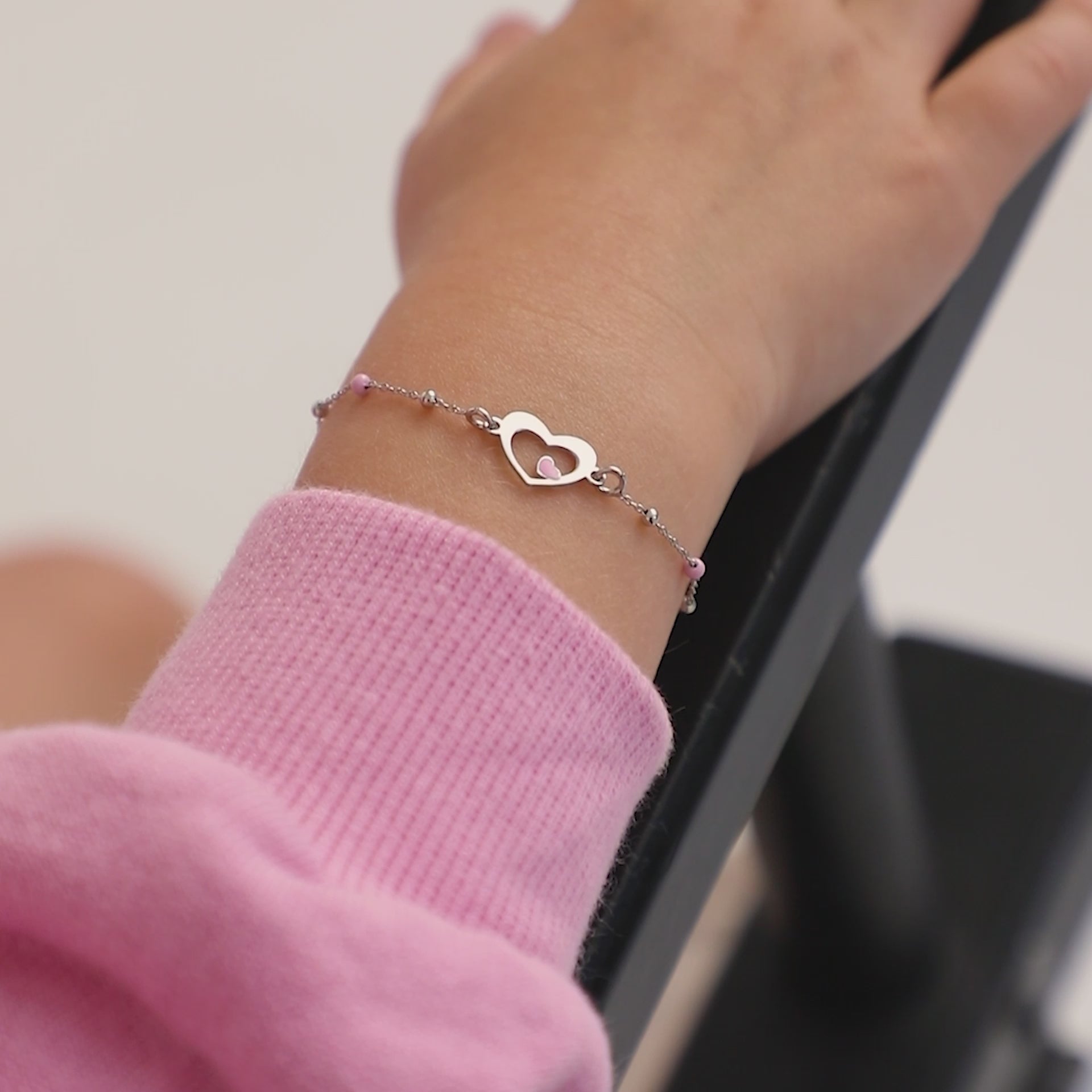 Age Group: Adorable for Toddlers, Young Girls &amp; Preteens; Safe for Sensitive Skin
Material: 925 Sterling Silver
Bracelet Size: 5 inches with extension up to 6", heart &amp; round beads (pink enamel); Adjustable
Metal Stamp: 925
Video of a young girl wearing sterling silver heart bracelet on her hand 