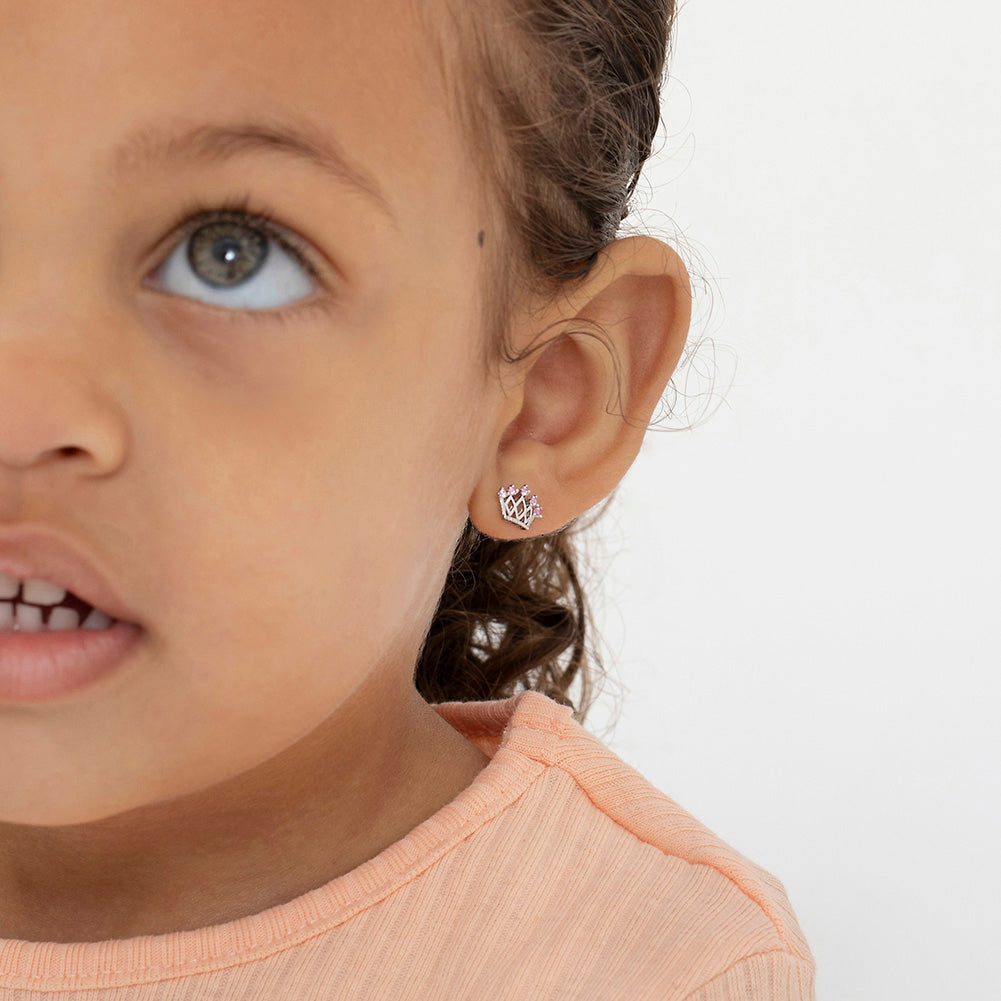 Age Group: Ideal for Toddlers, Young Girls or Pre-Teens; Safe for Sensitive Ears
Material: 925 Sterling Silver
Size: 10mm W x 7mm H crown; 9mm threaded earring post
Metal Stamp: 925
Window Box Included
5-point crown earrings with pink CZ. Picture close up of them being worn on a toddler