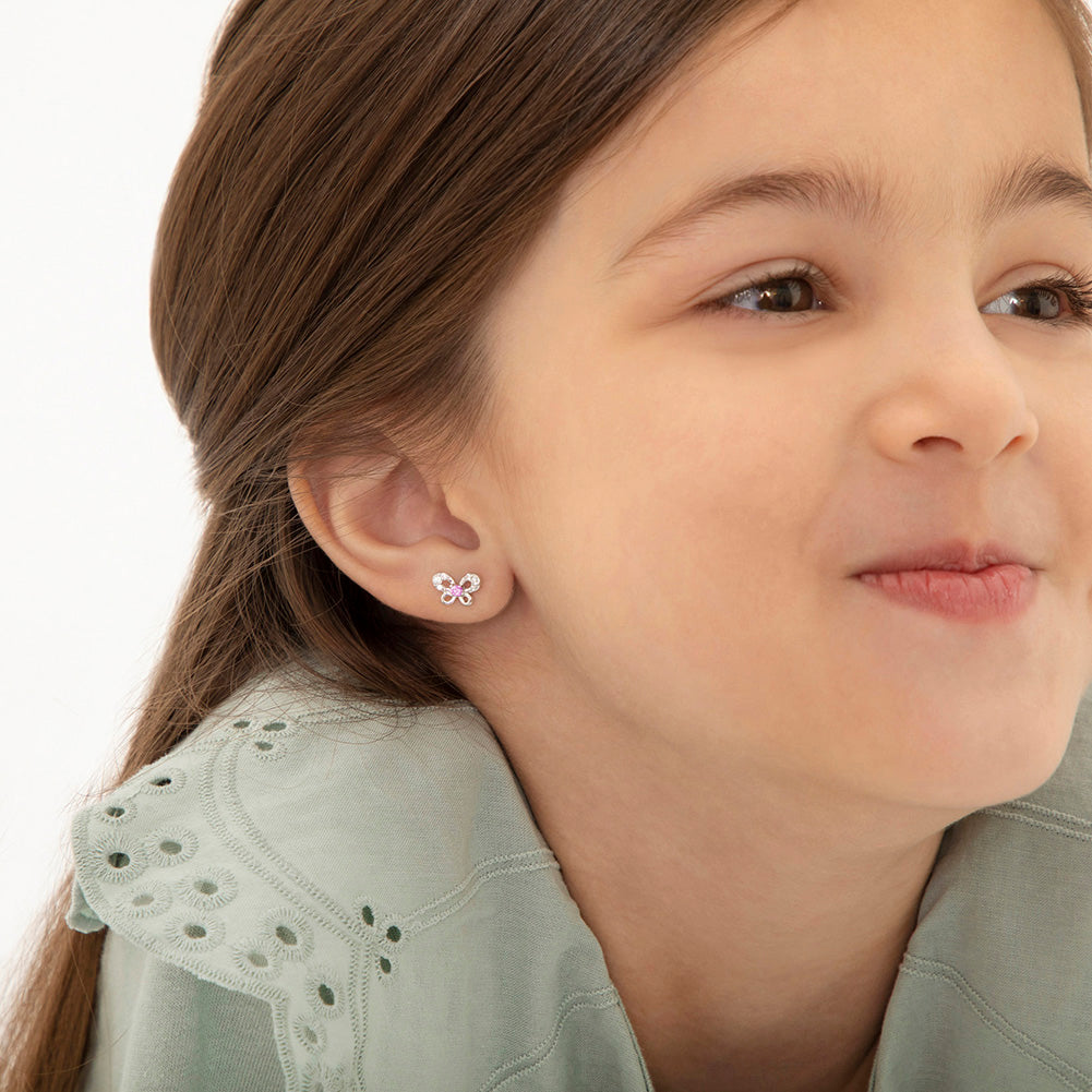 Age Group: Ideal for Infants, Toddlers and Girls; Safe for Sensitive Ears
925 Sterling Silver
Earrings Size: 9mm W x 6mm H Bow; 8mm post
Main Stone: Pink and Clear Cubic Zirconia
Metal Stamp: 925
Window Box Included
Butterfly earrings being worn by young girl close up
