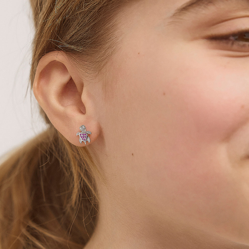 Age Group: Adorable for Little Girls, Young Teens to Teens (ages 5-15 years); Safe for Sensitive Ears
Material: 925 Sterling Silver
Earrings Size: 8mm W x 10mm H turtle, cubic zirconia; 7mm threaded earring post
Metal Stamp: 925
Close up of the young girl wearing the turtle earrings