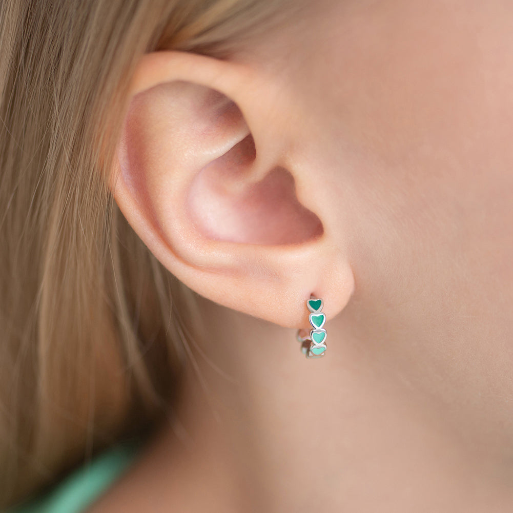 Age Group: Cute for Girls or Teens; Safe for Sensitive Ears
925 Sterling Silver
Earring Size: Outer: 0.47 in. (12mm); Inner: 0.35 in. (9mm)
Metal Stamp: 925
Cascading heart design with multiple green tone earrings on sterling silver. Picture of close up of young girl's ear with the earring on. 